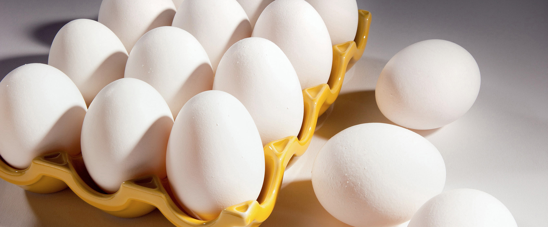 An open carton of a dozen eggs