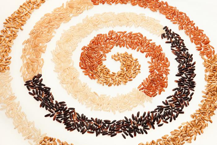 White, brown, red and black rice swirled in a circle shape.