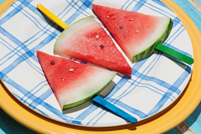 Three slices of fresh watermelon on a blue and white plate