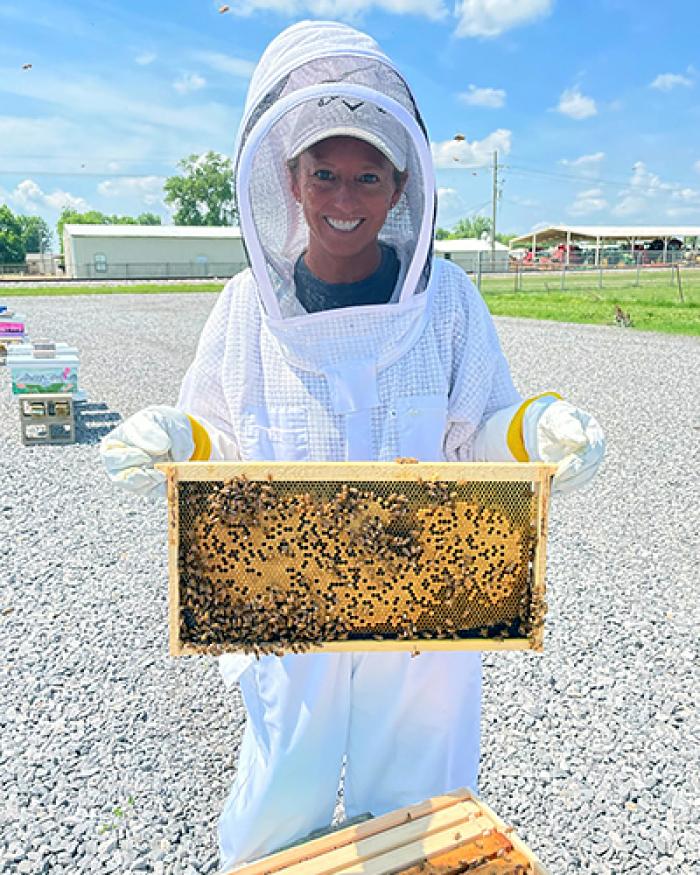 Biological science technician Amy Ray holding a brood frame.