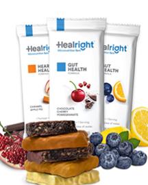 Three "Heal Right" micronutrient bars in their wrappers and surrounded by blocks of chocolate, blueberries and raspsberries