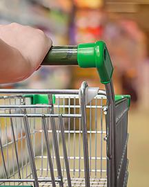 A green handled shopping cart being pushed down an aisle. Links to the Science in Your Shopping Cart section.  