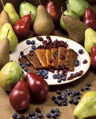 Pear fruit bars on a plate surrounded by pears, blueberries and cranberries. 