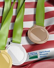 Gold, silver and bronze medals overlaying an American flag. 