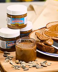 Sunbutter spread on a piece of bread and jars of Sunbutter next to it.  