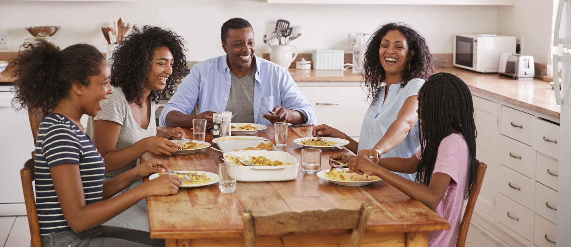 A happy family sitting at a dinner table. 