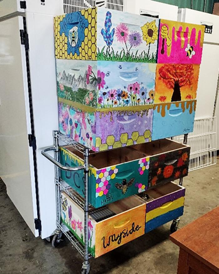 A stack of 10 bee boxes painted by students