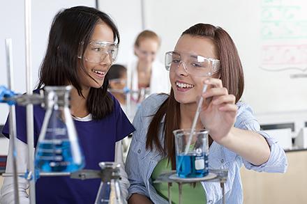 Girlslab Female high school students performing experiment in chemistry lab