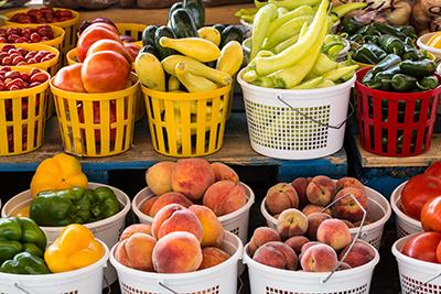 Basketsveggies Baskets of tomatoes, pepers, peaches and squash